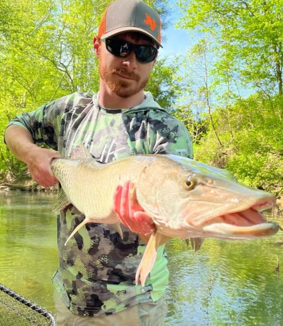 Fly fishing guide holding a musky